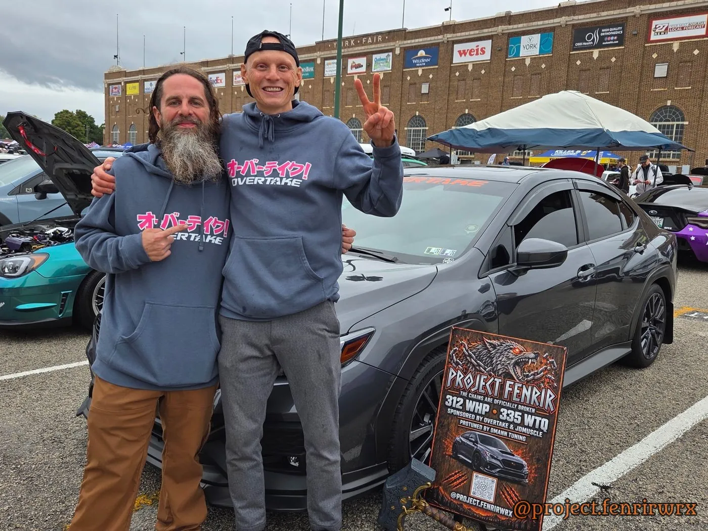 Don with Art Petrakov, Overtake co-founder, beside the car and the Project Fenrir show sign